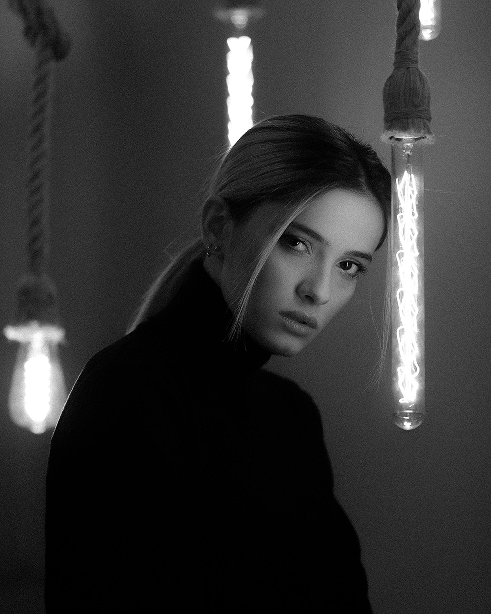 Photo d'une femme dans la pénombre en noir et blanc.